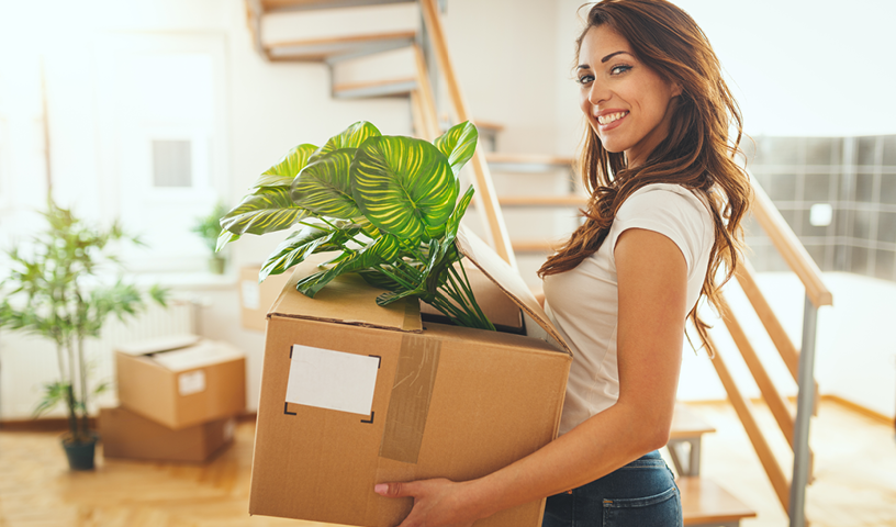 woman holding a plant preparing to move
