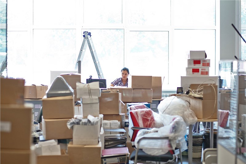 woman overwhelm by boxes of items for the office