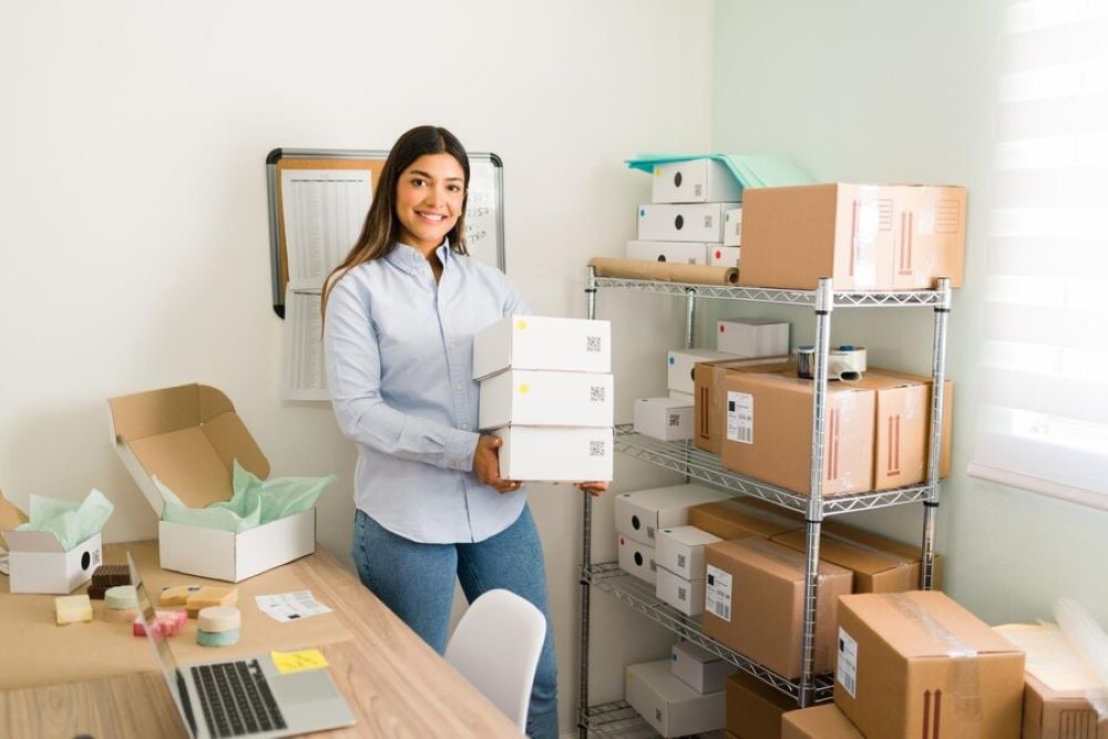 woman holding stack of small boxes