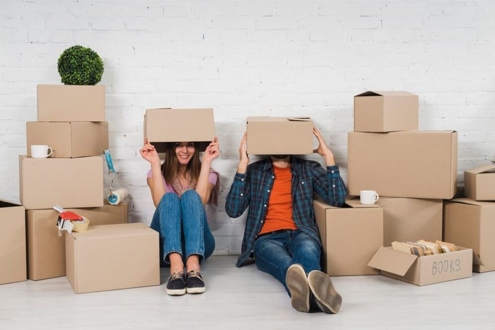 couple sitting covering there head with box