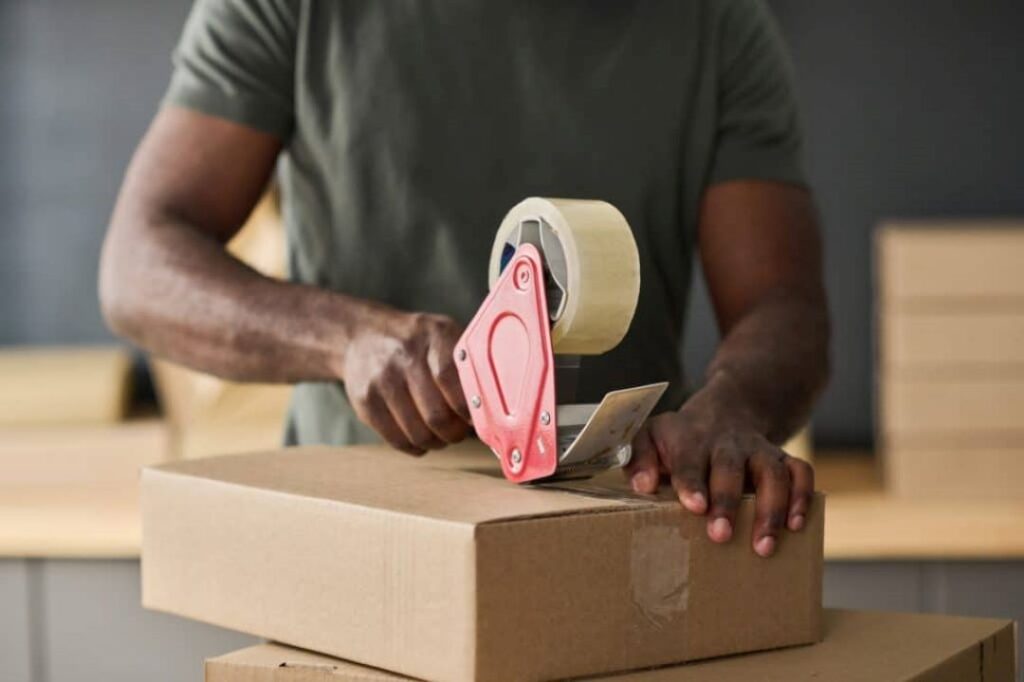 worker-packing-parcel-with-adhesive-tape