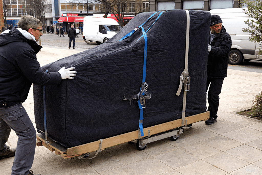 grand piano being prepared for transport