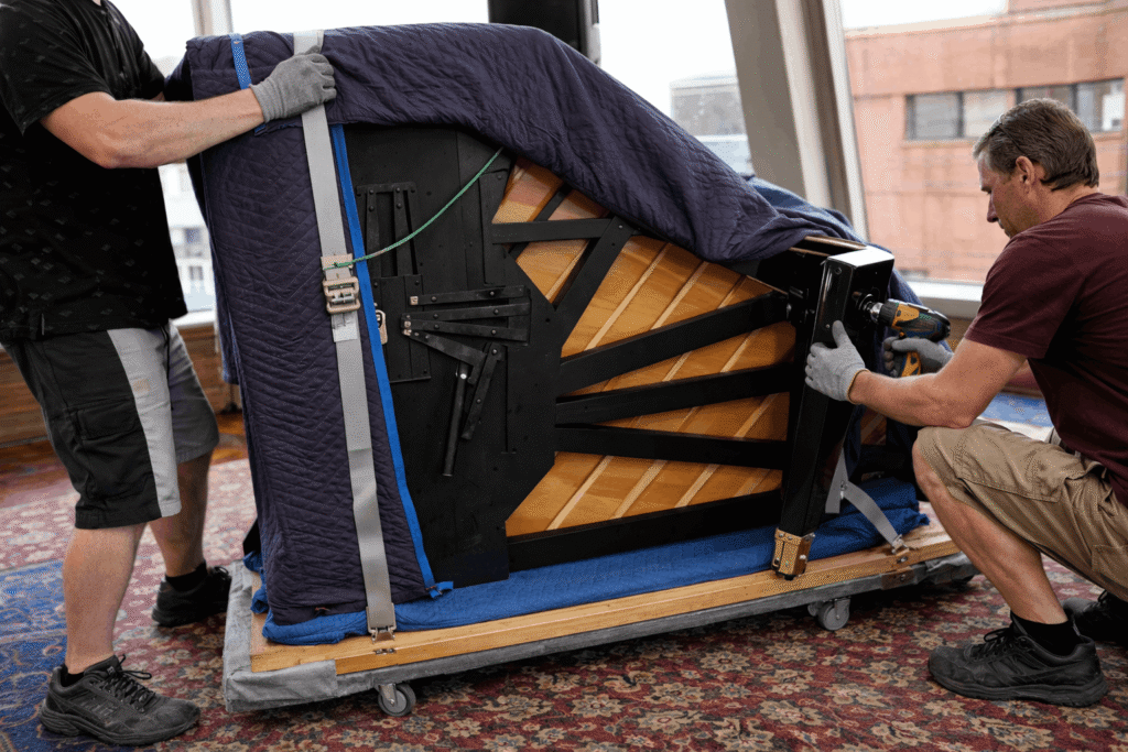 removalists removing the grand piano legs